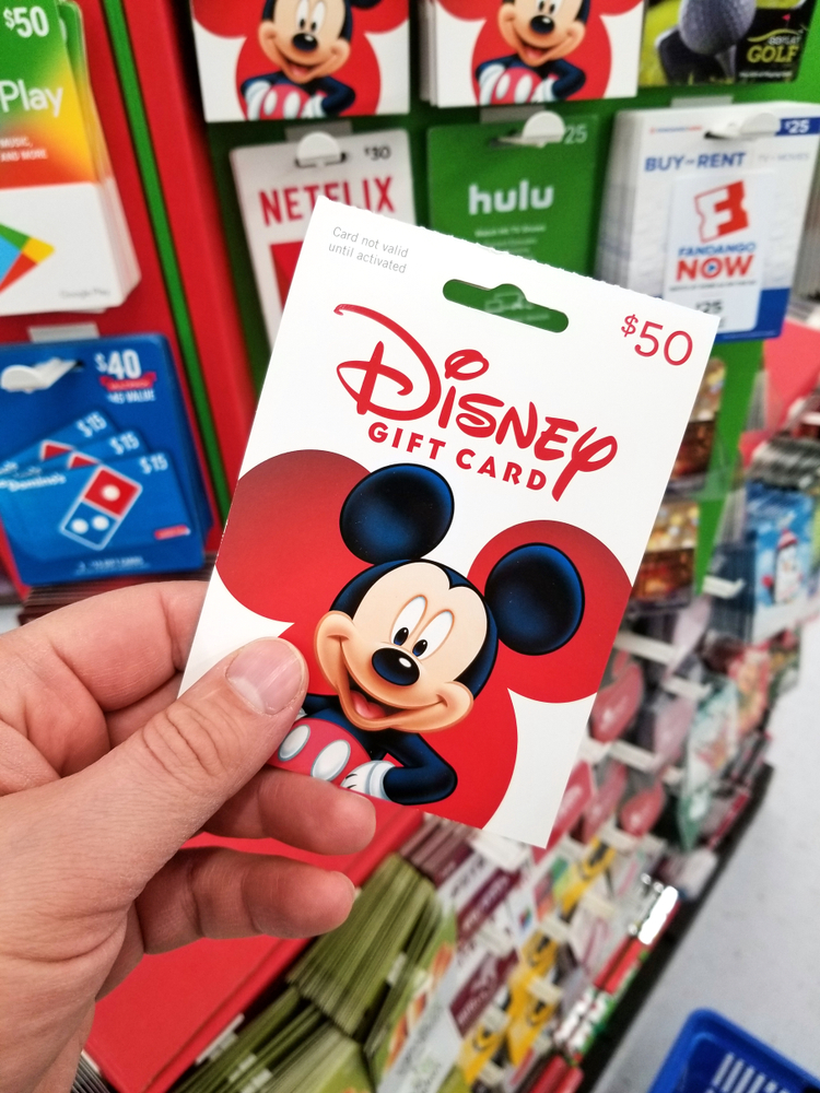 Photo of person holding discount Disney gift card.