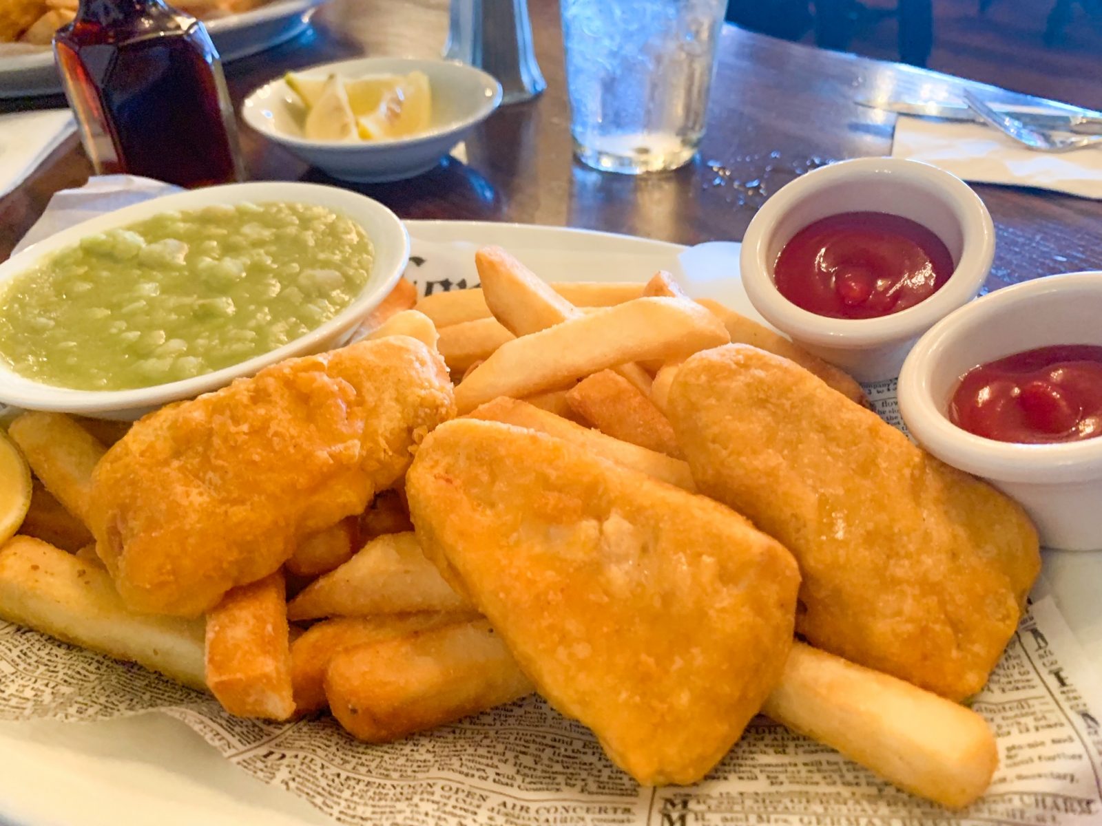 plate of fish and chips with mushy peas and ketchup 