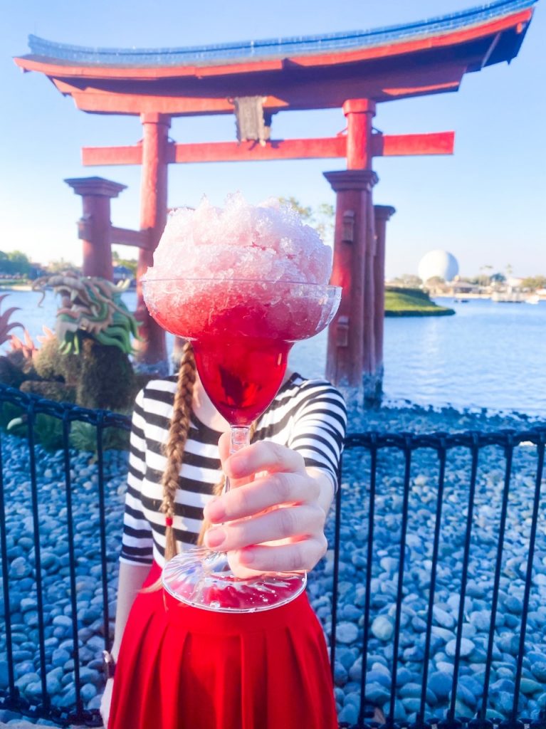 photo of an amazing drink in front of the World Showcase lake at Japan, Epcot. Try drinking around the world if you're on the Disney Dining plan plus