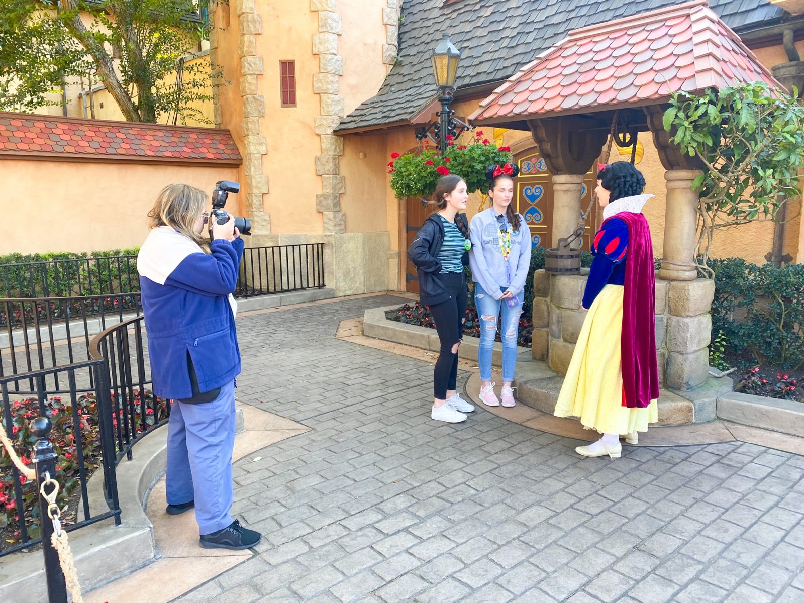 A photographer snaps live photos with guests and Snow White, while they take advantage of the Disney Memory Maker at this character meet and greet. 