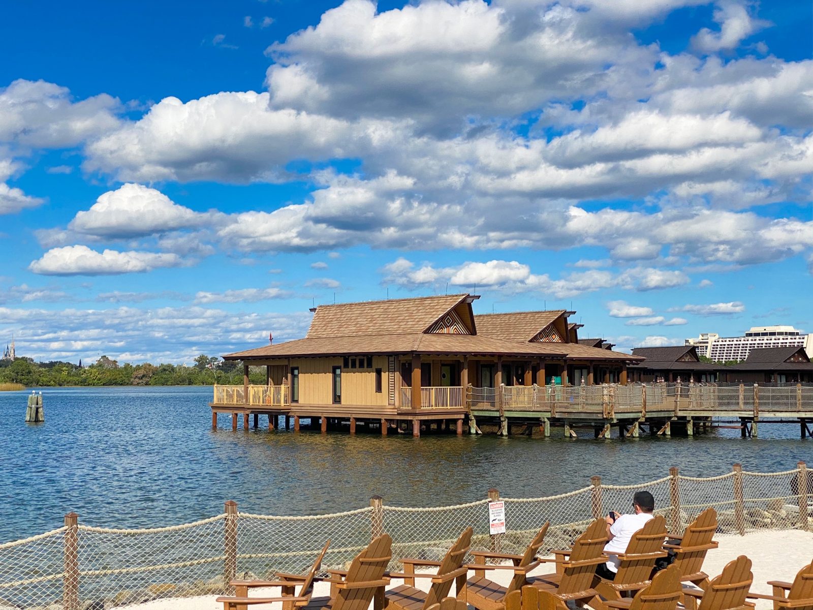 blue and cloudy sky above a wooden thatched style bungalow over water at the Polynesian disney monorail resort 