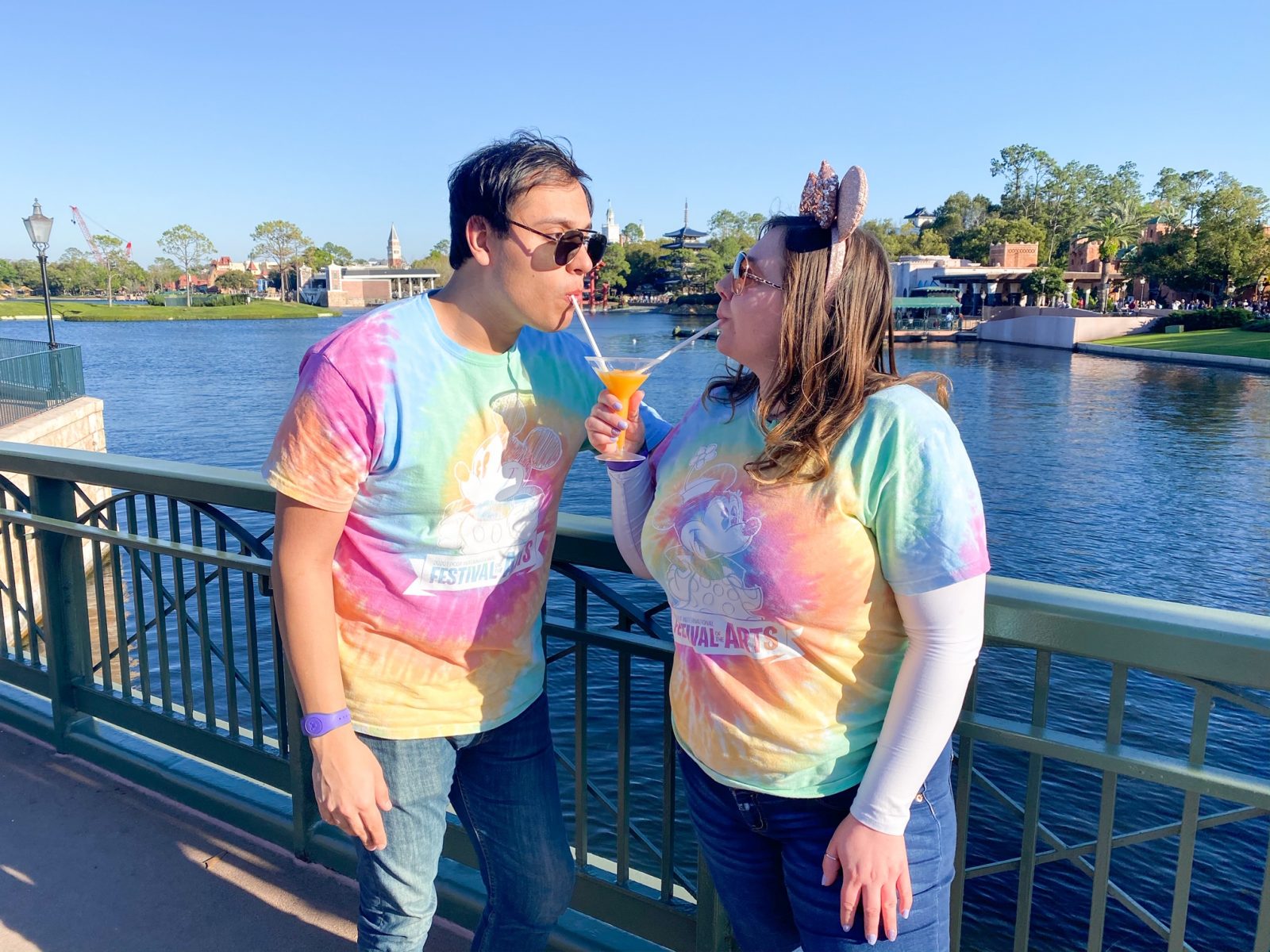 couple drinking around the world at Epcot with rainbow colored shirts