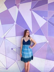 girl posing in front of geometric purple wall