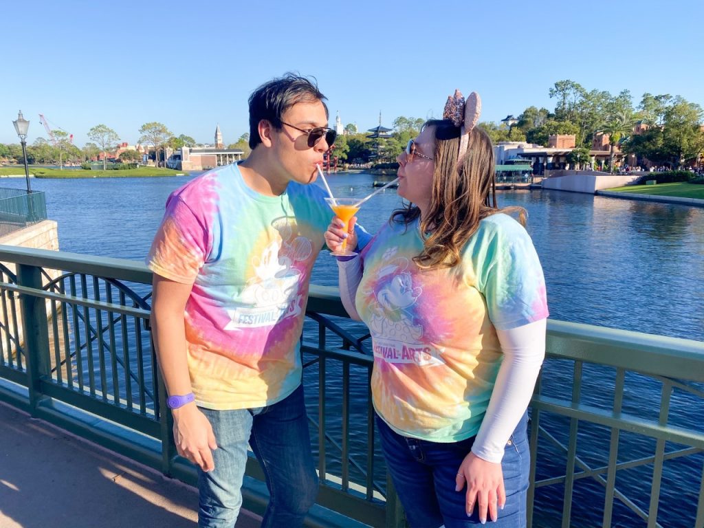 image of a couple in matching his and hers t-shirts sharing a drink - what to bring to Disney