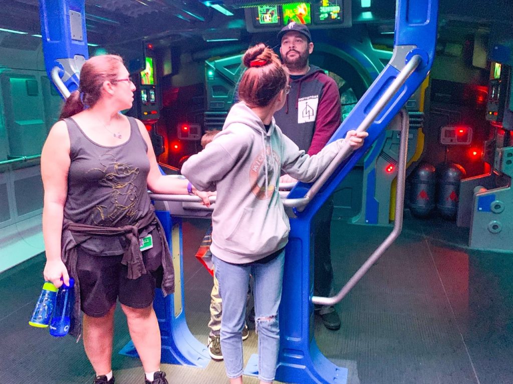 image of a family at a ride in Disney with water bottles - what to pack for Disney