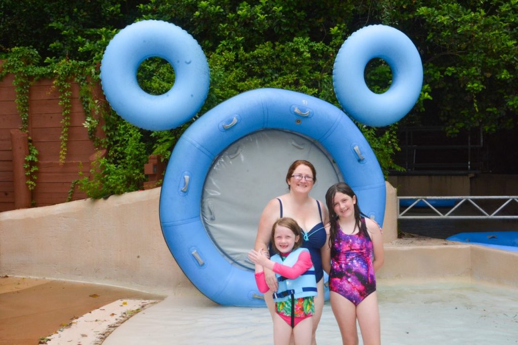 image of family in front of rafts/tubes arranged in hidden Mickey. Don't forget your photographs at the Disney Water Parks