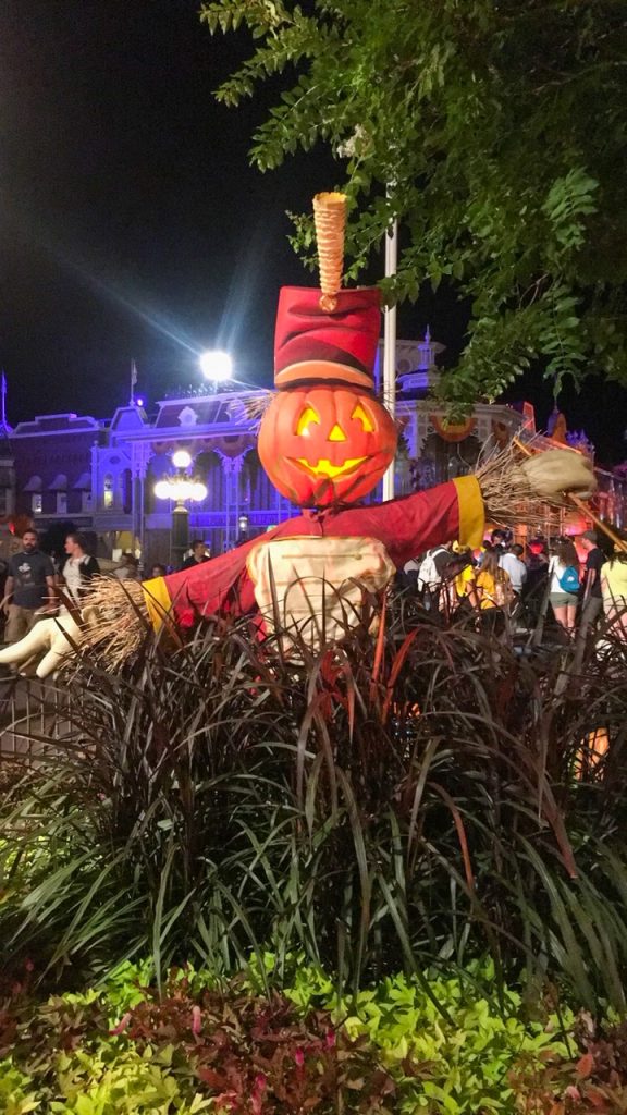 pumpkin dressed in a band uniform at the magic kingdom at night