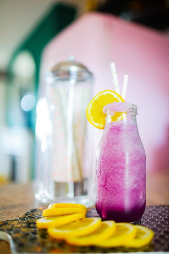 Epcot Violet Lemonade on counter with lemons and straws