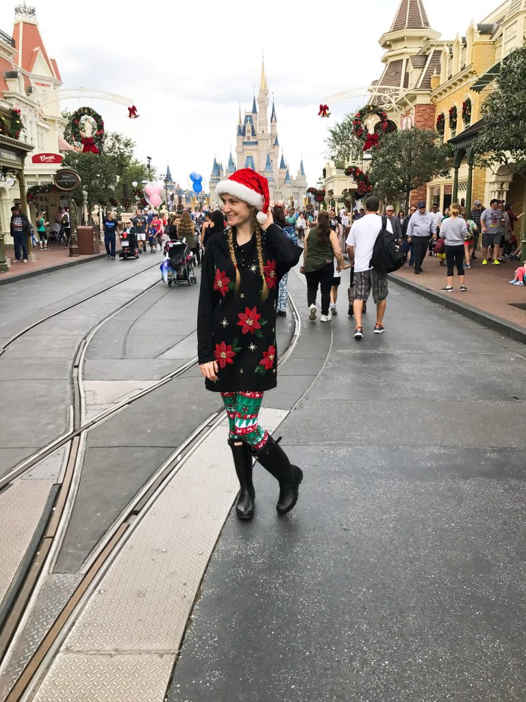 woman standing in cute christmas outfit showing different disney outfit ideas for winter