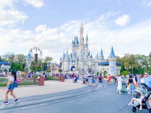 cinderella castle in the distance with people in front of it