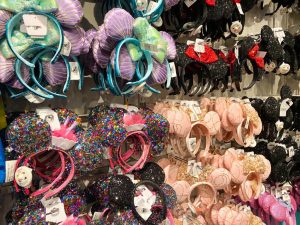 lots of colorful Minnie ears on a wall affordable souvenir for trip to disney cost