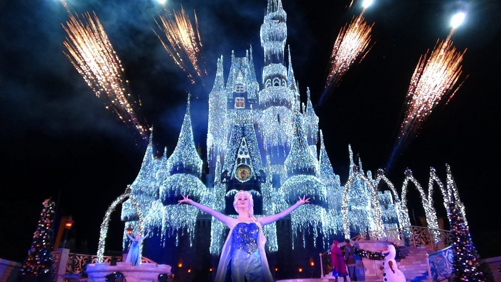 Elsa and friends in front of the decorated Cinderella Castle for a Disney Christmas celebration