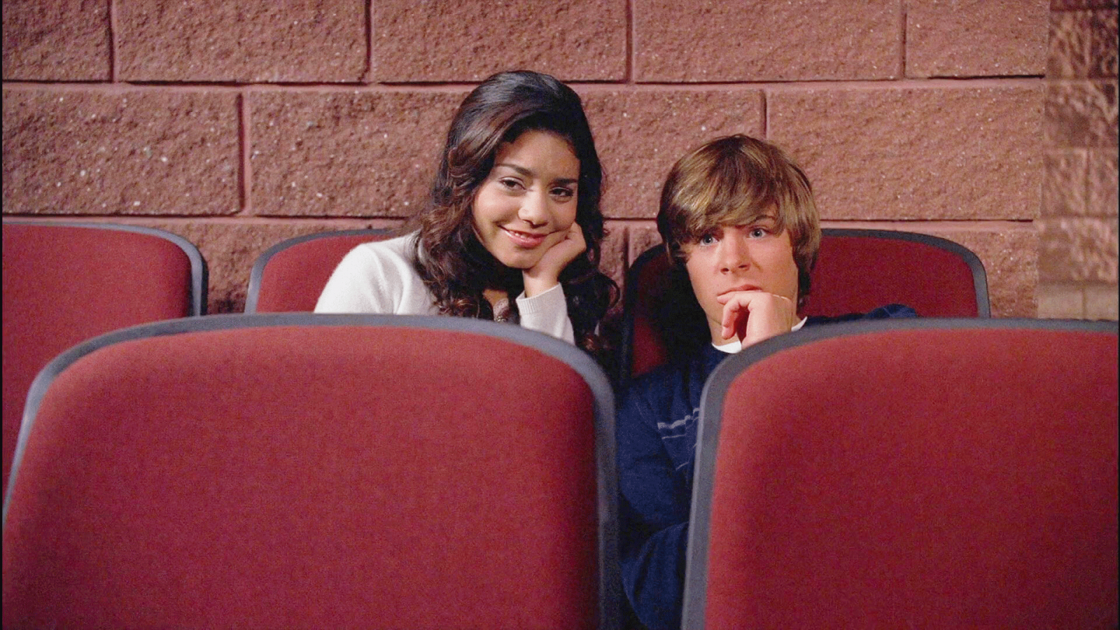 Troy and Gabrielle hiding in the back of the theatre