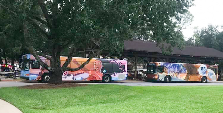 two buses picking up guests to go to the parks