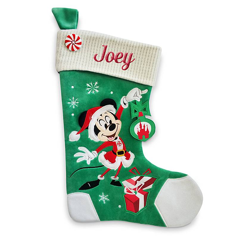 Mickey Mouse holds an ornament on a Christmas stocking