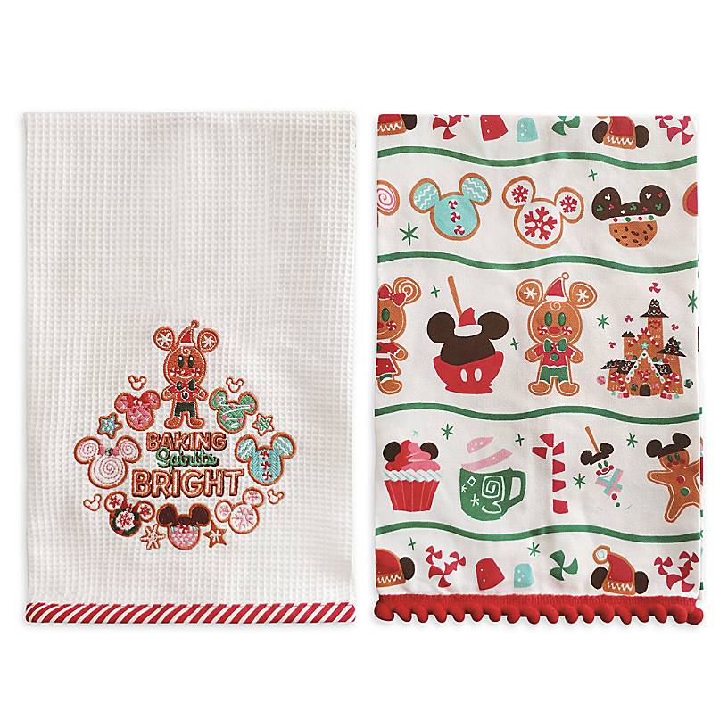 one white dish towel with the saying "Baking Spirits Bright" and one white dish towel with a Mickey sweets pattern