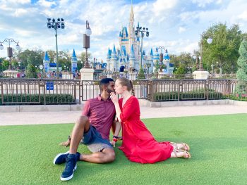couples kiss in front of cinderellas castle