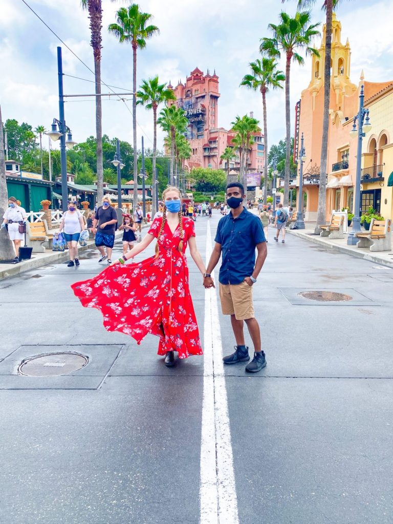 couple walking down sunset boulevard in front of the Tower of Terror