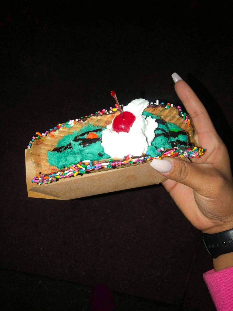 https://disneytrippers.com/wp-content/uploads/2021/01/disney-desserts-cookie-dough-taco-scaled.jpg