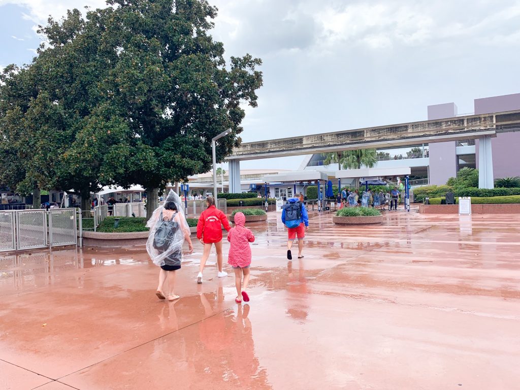 people wearing ponchos walking up to the Epcot entrance