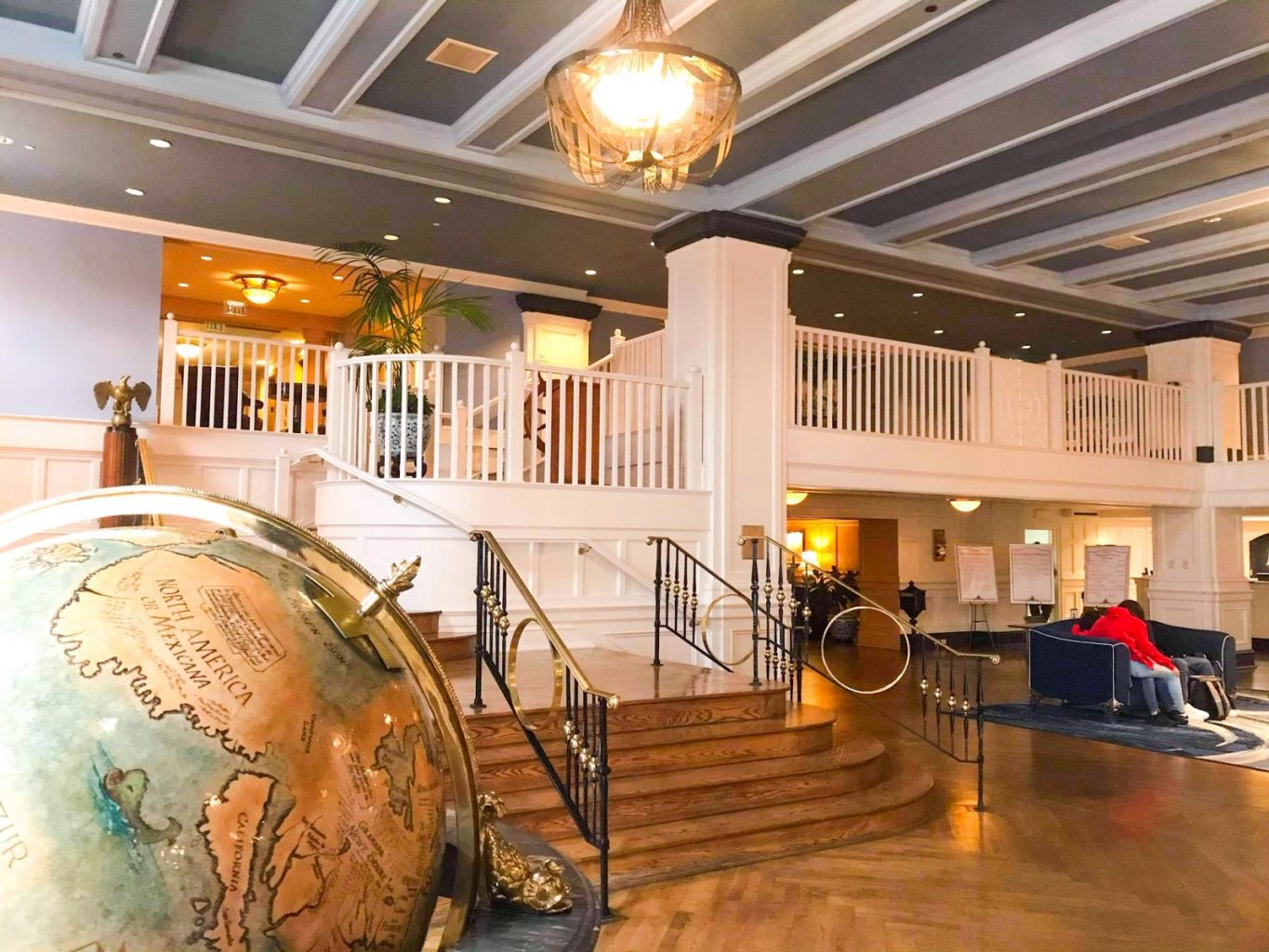 view of a big globe and the staircase inside the lobby of the Yacht Club Resort