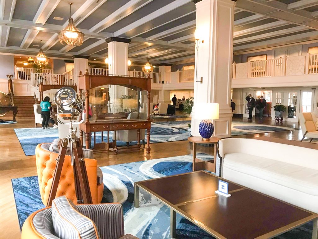 nautical themed lobby of the yacht club hotel at disney with chairs and globes and brown wood