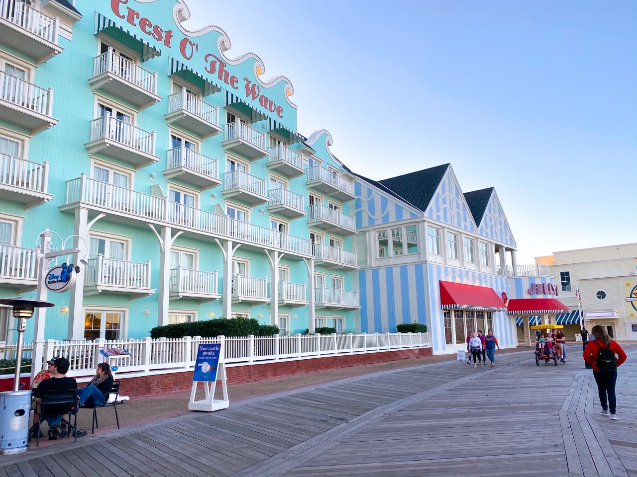 brightly colored hotel over a boardwalk outdoor dining at disney 