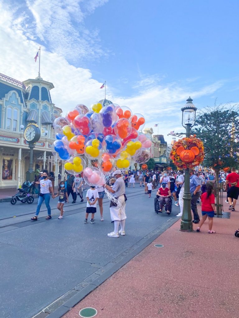 cast member holding Mickey balloons on Main Street 