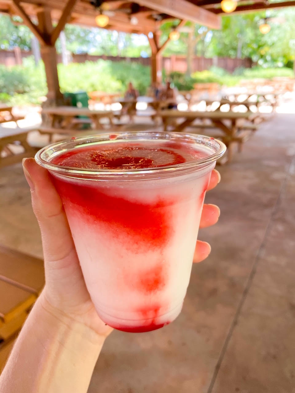 hand holding a frozen drink on patio