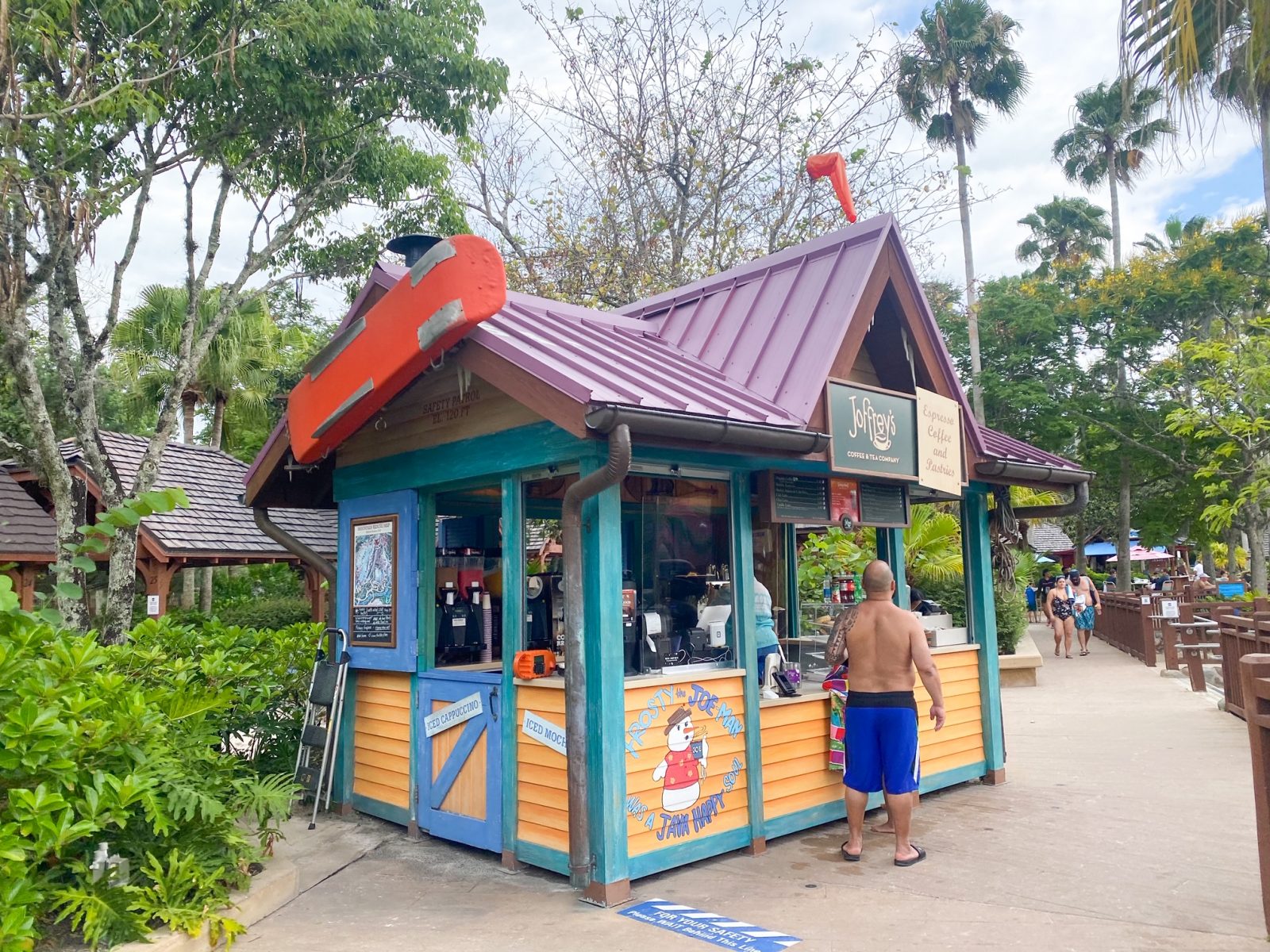 man at coffee kiosk and trees