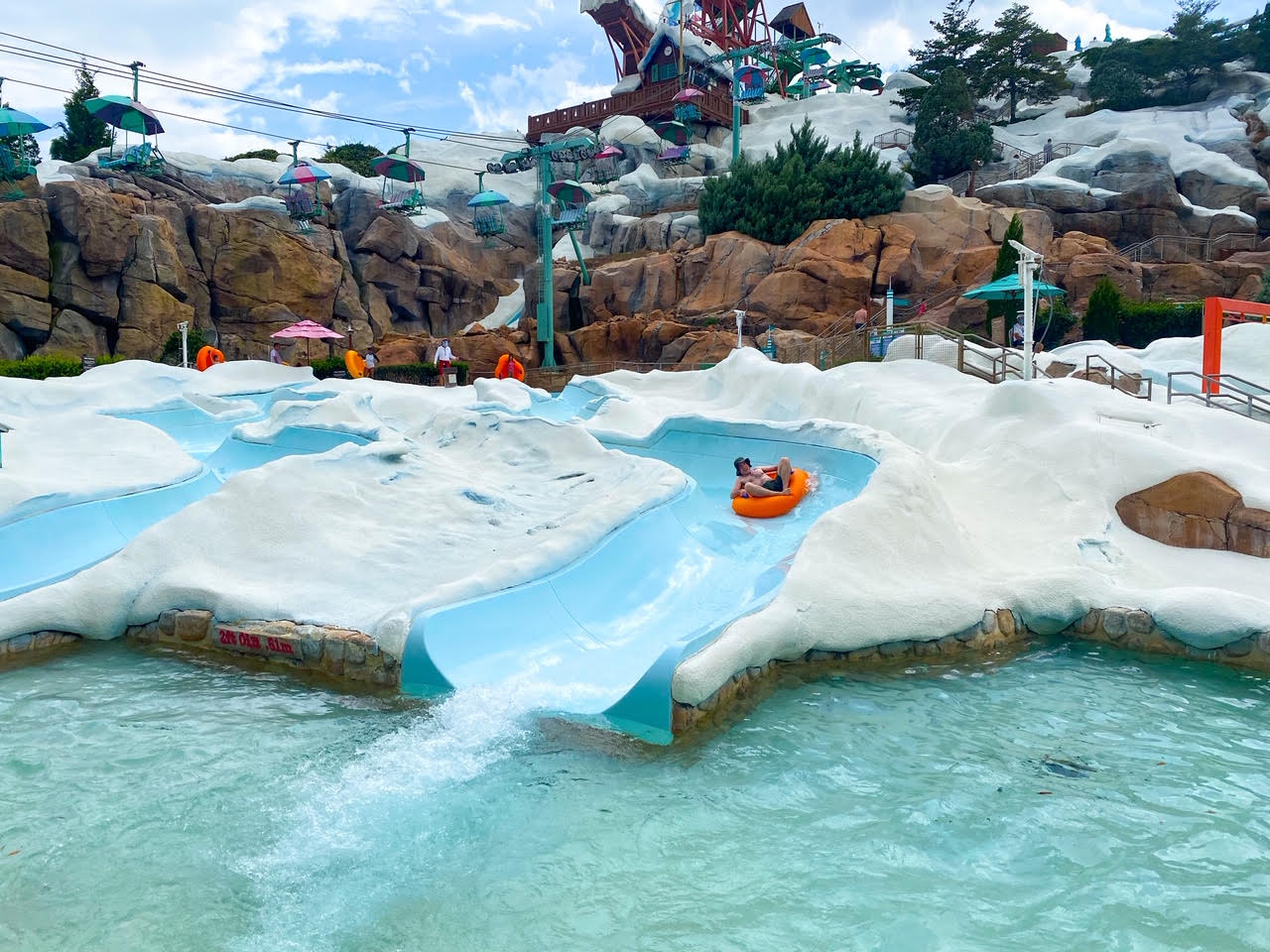 orange innertube slide, pool, and chair lifts