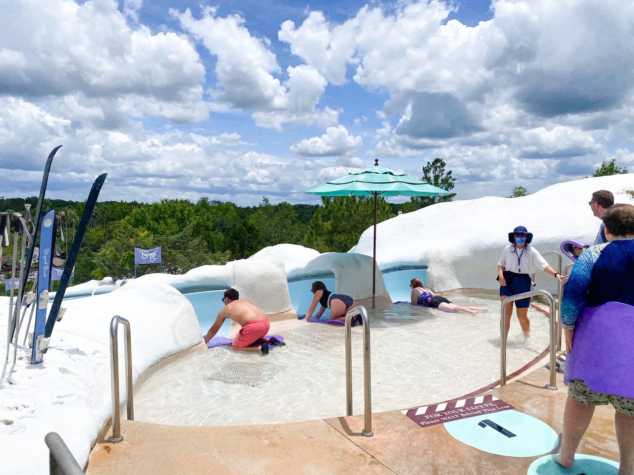 people preparing to go down mat racer waterslide and clouds