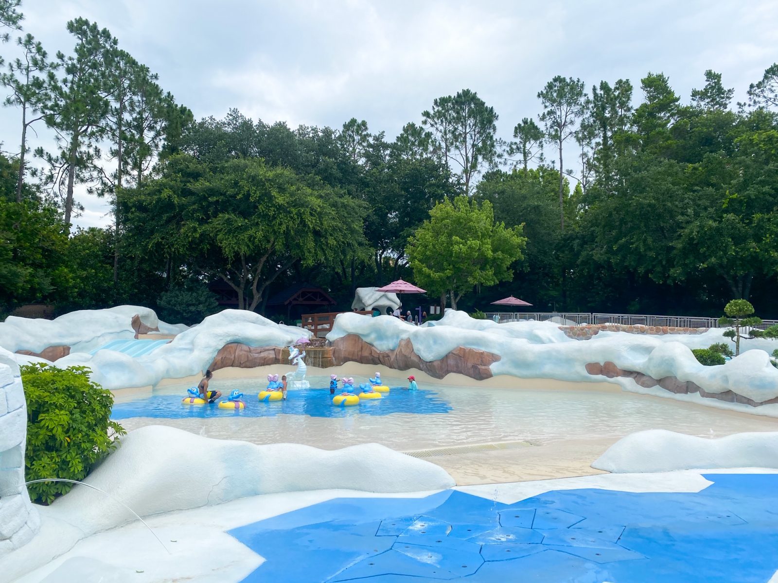 splash pad for kids, fake snow drifts, trees and clouds