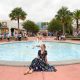 woman sits in front of fountain at Disney Springs