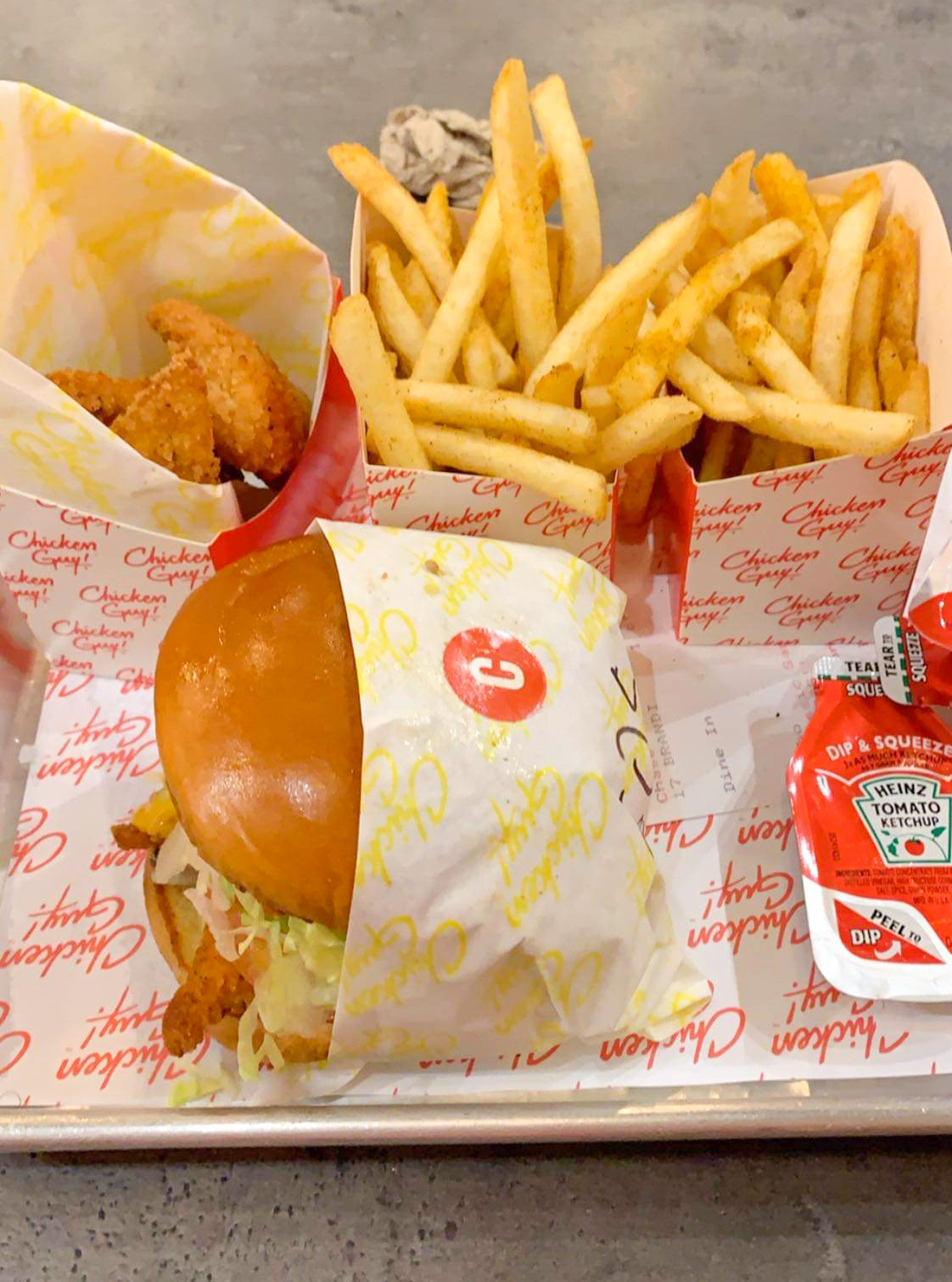 fries, chicken sandwich, and chicken tenders on tray at chicken guy