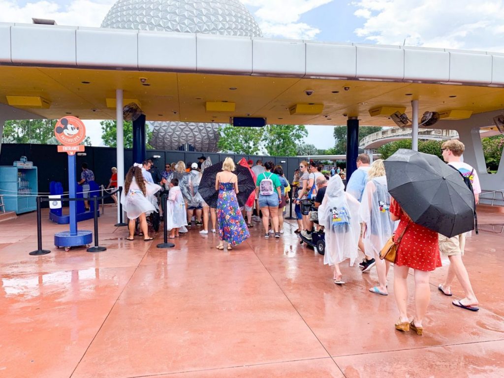 guests waiting to get in to Epcot in the rain