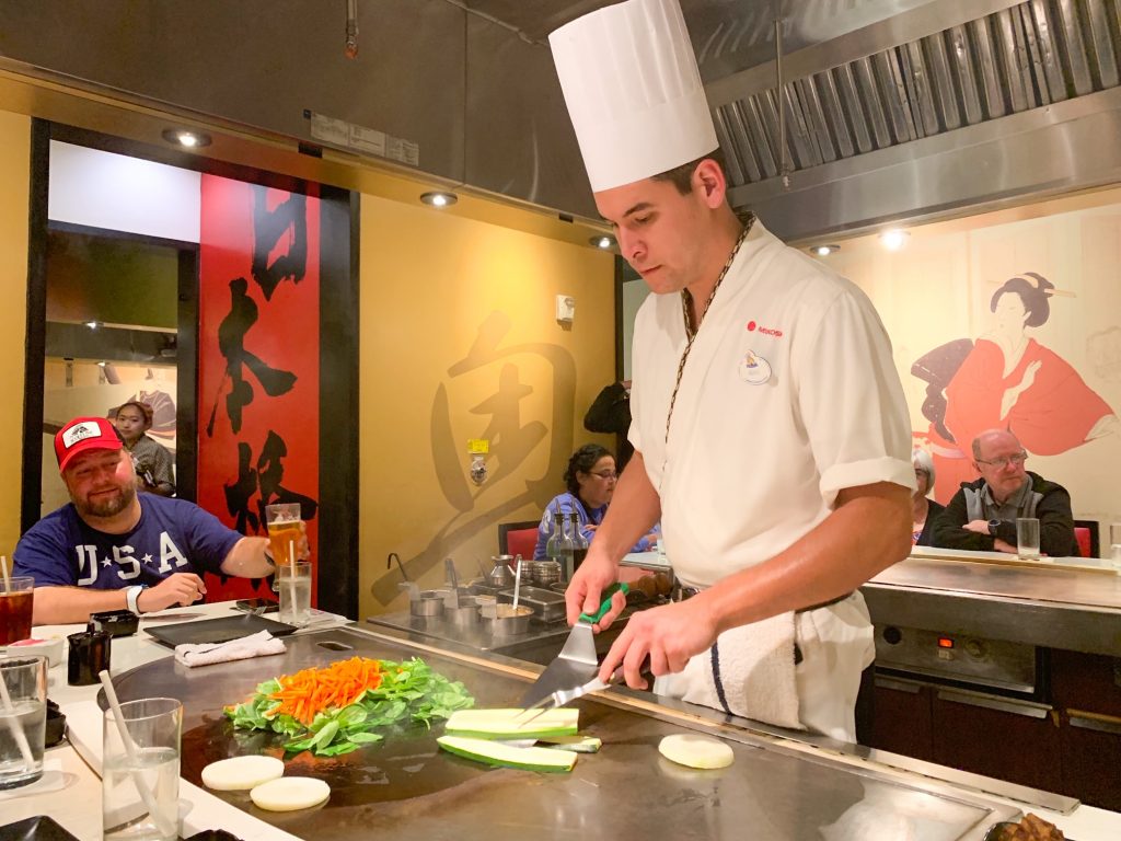 man cooking vegetables at japanese restaurant