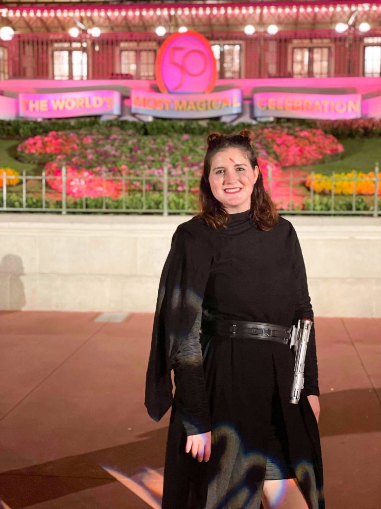 woman dressed as Kylo Ren in front of the entrance to Magic Kingdom