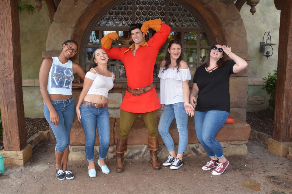 Four friends swoon next to a flexing Gaston: this character meet and greet was captured thanks to Disney Memory Maker! 