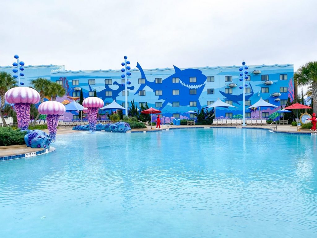 huge blue pool with giant purple jellyfish sculptures and Images of sharks on blue hotel building 