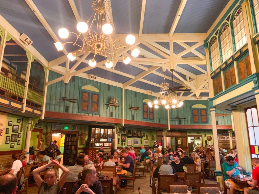 The interior of Skipper Canteen, with high ceilings, chandeliers, and an indoor-outdoor facade 