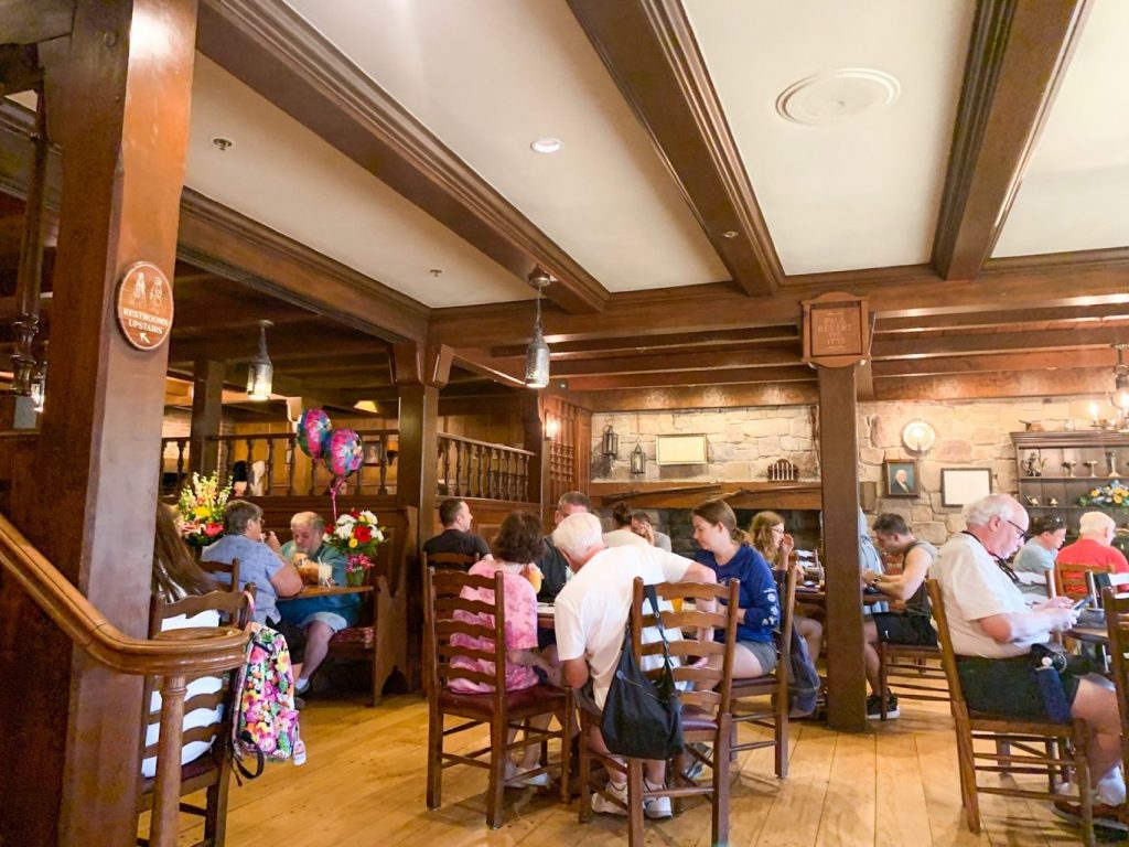 Liberty Tree Tavern's interior dining room with rustic tables and decor one of the best disney restaurants without reservations