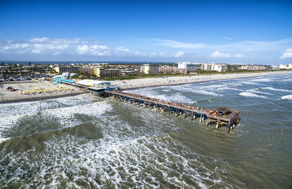 overhead shot of beach, shore, and a pier