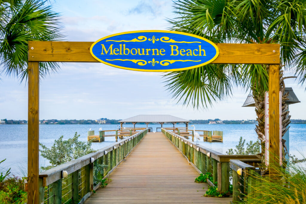 melbourne beach sign over pier and water