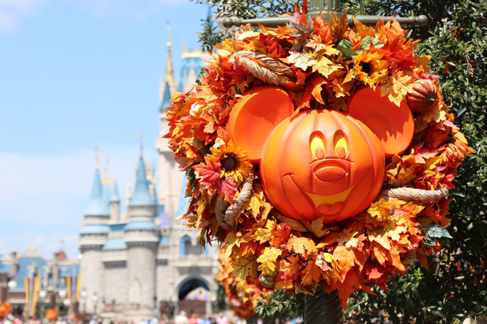 A Disney lamp post with a Halloween decorations on and the castle can be seen in the background 
