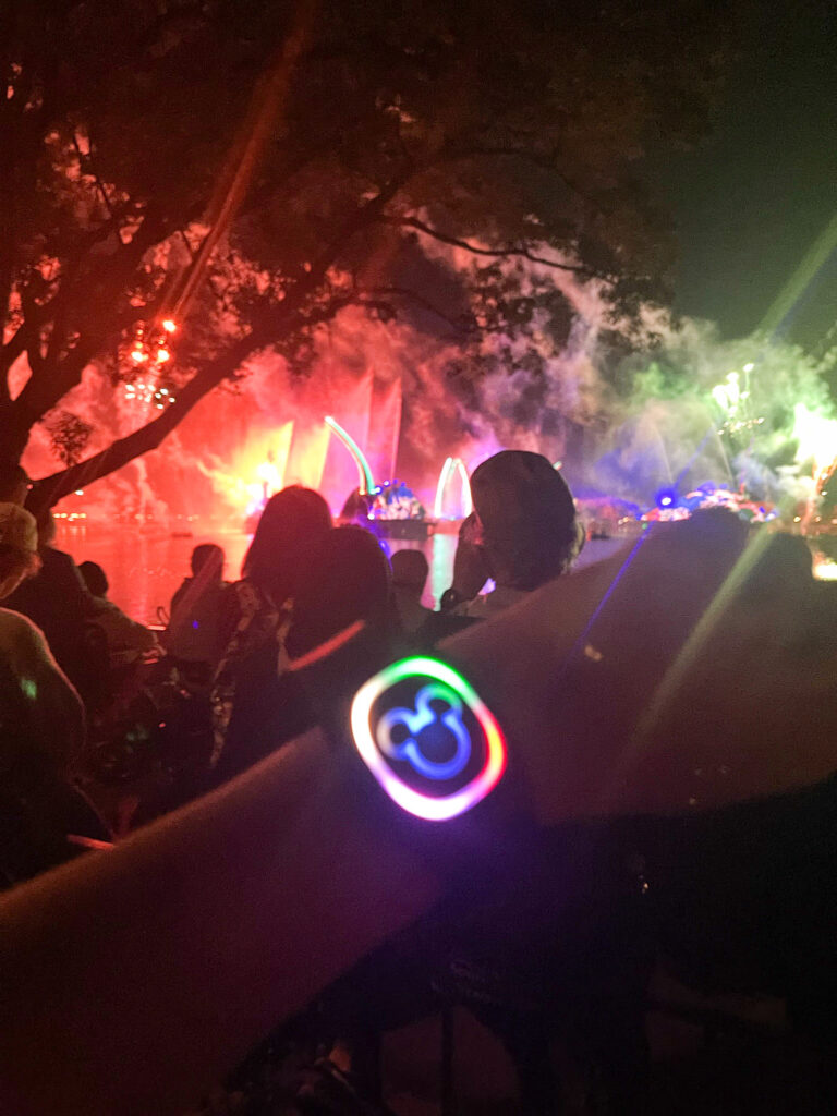 lit up magic band in front of fountain and light display