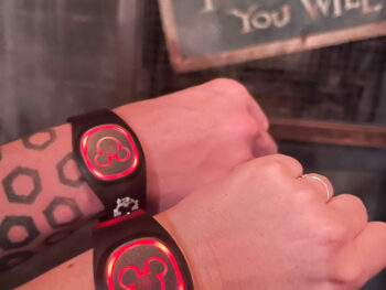 two lit up disney magic bands on wrists