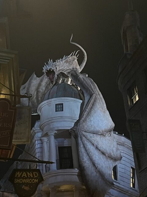 A dragon hovers of Gringotts-- the safest place on Earth-- in this night photo. The entrance to this ride-- which is one of the best rides at Universal Orlando-- is to the left of the dragon's wing. He breathes fire! 