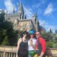 Three guests stand in front of Hogwarts Castle, which features one of the best rides at Universal Orlando -- Forbidden Journey!