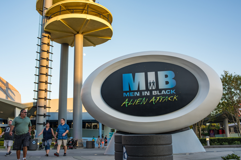 The sign for Men in Black Alien attack, which is one of the best rides at Universal Orlando, labels the entrance nearby a climb tower. 